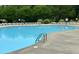 A large community pool surrounded by lounge chairs and lush greenery, perfect for relaxation and recreation at 228 Dove Cottage Ln, Cary, NC 27519