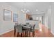 An open-concept dining area features modern décor, a view into the kitchen, and backyard access at 228 Dove Cottage Ln, Cary, NC 27519