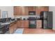 Well-lit kitchen features wooden cabinets, black appliances, sink and dark countertops at 228 Dove Cottage Ln, Cary, NC 27519