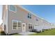 Grey vinyl siding backyard featuring a white fence, a back door, concrete patio, and a green lawn at 2312 Sugar Cone Way, Fuquay Varina, NC 27526