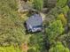 An aerial view showing the rear of the home, expansive trees, and screened porch with outdoor seating at 250 Highview Dr, Youngsville, NC 27596