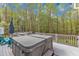 Large back deck features a hot tub, grill, and wooded views perfect for outdoor relaxation at 250 Highview Dr, Youngsville, NC 27596