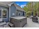 Back deck with hot tub, grill, and outdoor seating with a natural wooded backdrop at 250 Highview Dr, Youngsville, NC 27596
