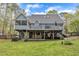 Home exterior with deck overlooking a large backyard with mature trees and lush grass at 250 Highview Dr, Youngsville, NC 27596