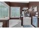 Well-lit bathroom with a soaking tub, stained glass window, and nautical decor creates a charming retreat at 250 Highview Dr, Youngsville, NC 27596