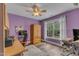 Bright bedroom with purple walls, wood floors, and a large window overlooking the yard at 250 Highview Dr, Youngsville, NC 27596