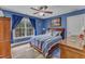 Bedroom with blue walls, hardwood floors, ceiling fan, and large window at 250 Highview Dr, Youngsville, NC 27596