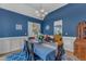 Dining room with wainscoting and blue walls, featuring hardwood floors and chandelier lighting at 250 Highview Dr, Youngsville, NC 27596