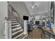 Cozy living room with a fireplace, staircase, hardwood floors, and plush seating arrangements at 250 Highview Dr, Youngsville, NC 27596