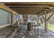 Outdoor stone patio with a custom barrel table, chairs, and view of the wooded backyard at 250 Highview Dr, Youngsville, NC 27596