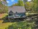 An elevated rear view showcasing a house featuring a large deck with a hot tub and ample outdoor space at 250 Highview Dr, Youngsville, NC 27596