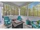 Bright screened porch with tile floors, comfortable seating, and peaceful view of the wooded area at 250 Highview Dr, Youngsville, NC 27596