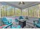 Inviting screened porch with tile floors, comfortable seating, and peaceful view of the wooded area at 250 Highview Dr, Youngsville, NC 27596
