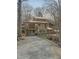 Rear view of a charming home with an upper deck, screened porch, and gravel driveway at 2811 Chicken Bridge Rd, Pittsboro, NC 27312