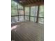 Spacious screened-in porch with wooden floors and ceiling fan, perfect for relaxation at 2811 Chicken Bridge Rd, Pittsboro, NC 27312