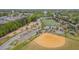 Expansive aerial view of community baseball, soccer fields, and lush green surroundings with trees and neighborhood streets at 311 Culvert St, Apex, NC 27502