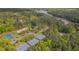 Lush aerial view showcasing tennis and basketball courts surrounded by trees, a lake and neighborhood at 311 Culvert St, Apex, NC 27502