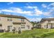 Exterior backyard view of the townhome featuring sliding glass doors and well-kept lawn with neighboring townhomes at 345 Red Elm Dr, Durham, NC 27713