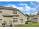 Exterior view of the townhome featuring sliding glass doors, trash receptacles, and a well-kept lawn at 345 Red Elm Dr, Durham, NC 27713