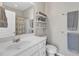 Bright bathroom features a white vanity with silver fixtures, a toilet, shelving, and neutral paint at 345 Red Elm Dr, Durham, NC 27713