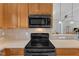 Stove top featuring stainless steel appliances and wood cabinetry at 345 Red Elm Dr, Durham, NC 27713