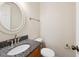 Charming half bathroom with granite countertop and round mirror at 3518 Donnigale Ave, Durham, NC 27705