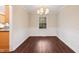An elegant dining room with wainscoting, hardwood floors, and a view of the backyard through a window at 3518 Donnigale Ave, Durham, NC 27705