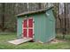 A charming outbuilding, perfect for storage, with security cameras on green-painted siding and red doors at 3518 Donnigale Ave, Durham, NC 27705