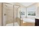Bathroom featuring a glass-enclosed shower, soaking tub, neutral tile, and bright natural light at 4008 Sykes St, Cary, NC 27519