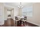 Dining room featuring wood floors, a modern chandelier, a window with blinds, and a dining table with seating for four at 4008 Sykes St, Cary, NC 27519