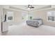A spacious main bedroom with a tray ceiling, carpeting, a ceiling fan, and large windows providing ample natural light at 4008 Sykes St, Cary, NC 27519