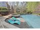 Relaxing backyard pool featuring a spa, shallow water seating, and mature trees at 417 Westbury Dr, Chapel Hill, NC 27516