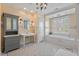A bathroom features yellow walls, white tile floors, bathtub with plantation shutters, and grey cabinets at 417 Westbury Dr, Chapel Hill, NC 27516