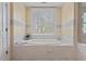 A bathroom features a tiled bathtub surrounded by plantation shutters, and a view from the window at 417 Westbury Dr, Chapel Hill, NC 27516