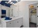 Bright bathroom featuring a large mirror, white cabinets, and an open closet for linens at 417 Westbury Dr, Chapel Hill, NC 27516