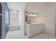 A bright bathroom with a large arched window, a big vanity, and white tile floors at 417 Westbury Dr, Chapel Hill, NC 27516