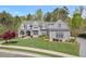 Beautiful gray home with a well-manicured lawn and mature landscaping on a sunny day at 417 Westbury Dr, Chapel Hill, NC 27516