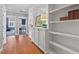 Hallway featuring hardwood floors, white built-in shelving, and transomed doorway at 417 Westbury Dr, Chapel Hill, NC 27516