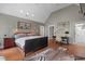 A main bedroom features hardwood floors, a bed, a zebra rug, artwork, and a dark wood desk at 417 Westbury Dr, Chapel Hill, NC 27516