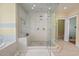 A white tiled shower with glass doors features a corner seat and three shower heads at 417 Westbury Dr, Chapel Hill, NC 27516