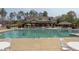 Large community swimming pool with tables, chairs, and a clubhouse in a wooded setting at 452 Panorama Park Pl, Cary, NC 27519