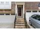 Close-up of a brick townhome entrance with dark-stained front door and a two-car garage at 452 Panorama Park Pl, Cary, NC 27519