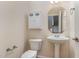 Clean and simple half bathroom with pedestal sink, toilet, and mirrored cabinet at 452 Panorama Park Pl, Cary, NC 27519