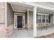 Inviting covered porch with seating, brick accents, and stylish front door, enhancing curb appeal at 4712 Bright Pebble Ct, Raleigh, NC 27604