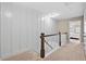 Upstairs hallway with wainscoting, carpet, and stairs at 5 Galway Glenn Ln, Durham, NC 27705