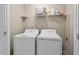 Functional laundry room featuring a washer, dryer, and shelf space, perfect for efficient laundry care at 5 Galway Glenn Ln, Durham, NC 27705