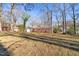 Spacious backyard featuring a brick home with mature trees providing ample shade and natural beauty at 5013 Green Oak Dr, Durham, NC 27712