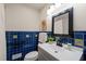 Bathroom boasts blue tiling, floral accents and modern fixtures at 5013 Green Oak Dr, Durham, NC 27712