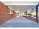 Carport exterior with brick accents, white ceiling, and a gravel driveway at 5013 Green Oak Dr, Durham, NC 27712
