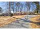 Charming single-story brick home with large trees, a gravel driveway, and a carport at 5013 Green Oak Dr, Durham, NC 27712